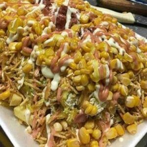 Chuzo desgranado de cerdo acompañado de maíz, queso, ripio de papa y salsas.